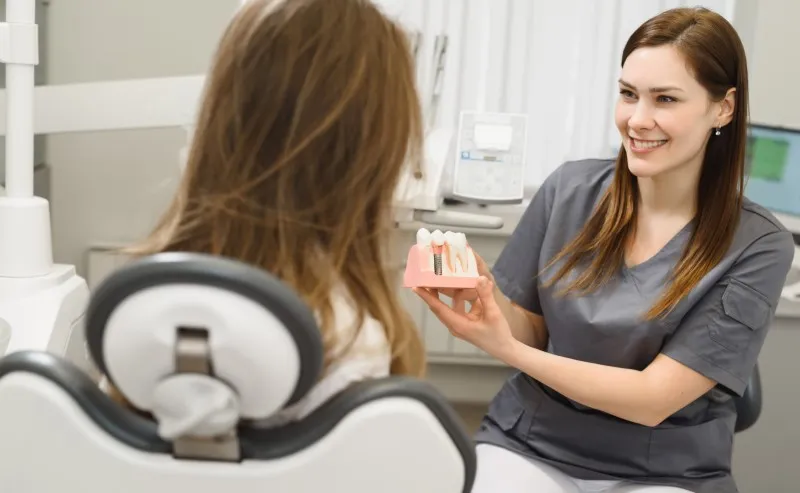 dentista feminina mostrando implante dental odontologia faculdade soberana