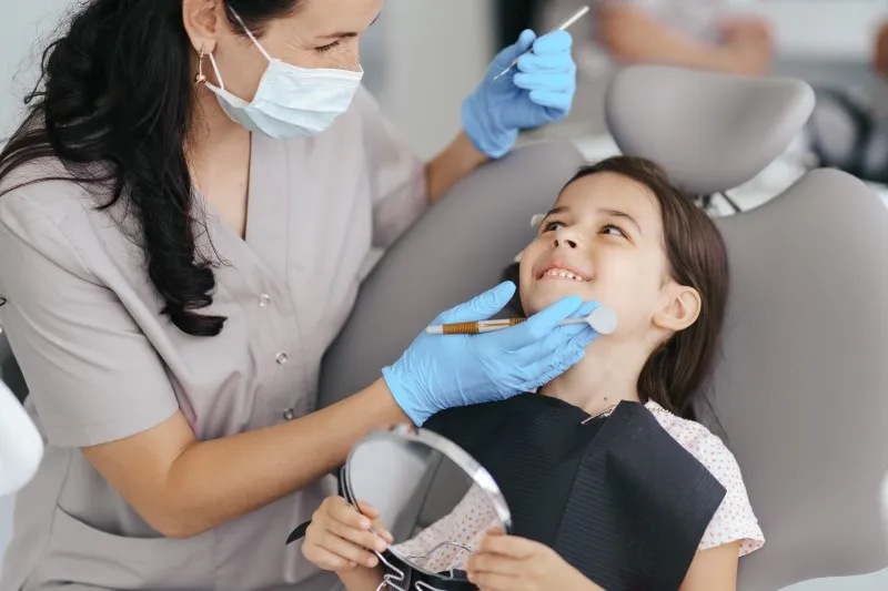 dentista mulher atendendo criança odontopediatria